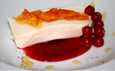 panna cotta con chocolate blanco, naranja y frutos rojos