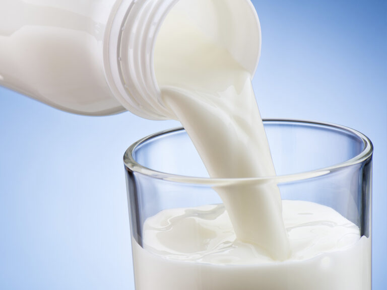 Leche siendo vertida en vaso de cristal