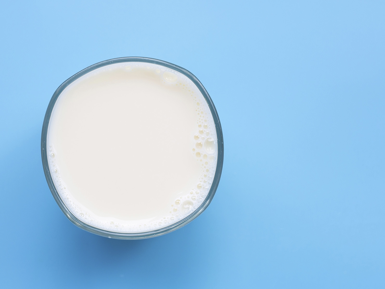 Vaso de leche vista superior fondo azul