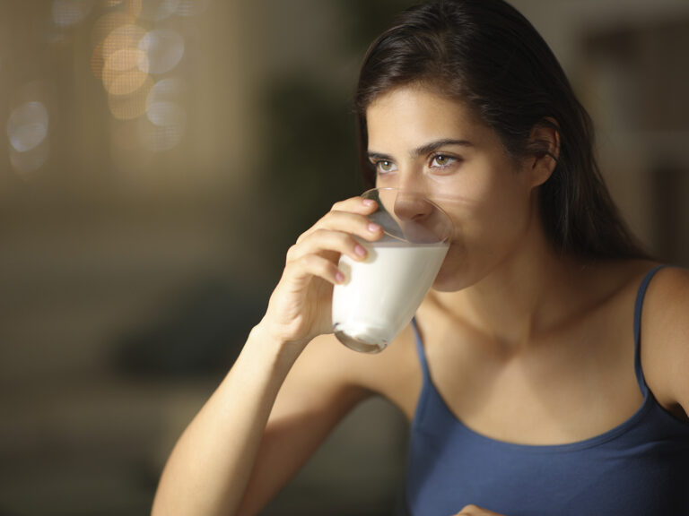 Mujer bebiendo leche fresca de un vaso