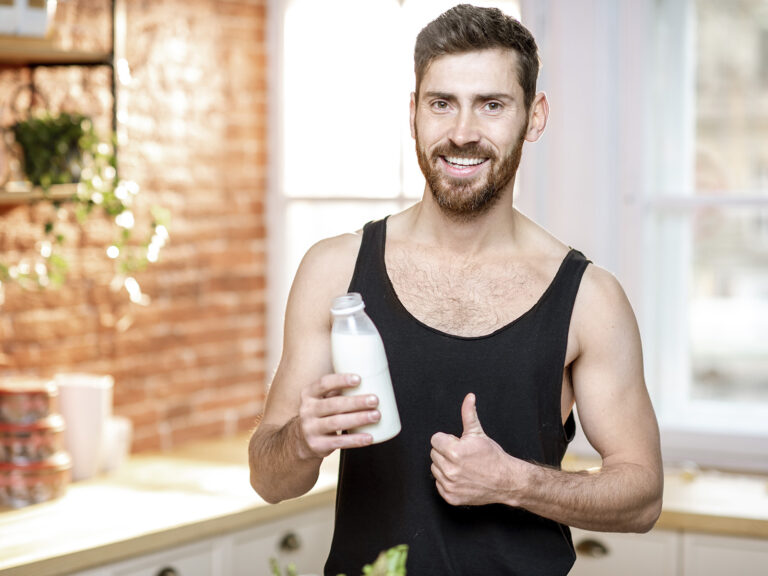 Deportista hombre sosteniendo botella de suplemento Omega 3