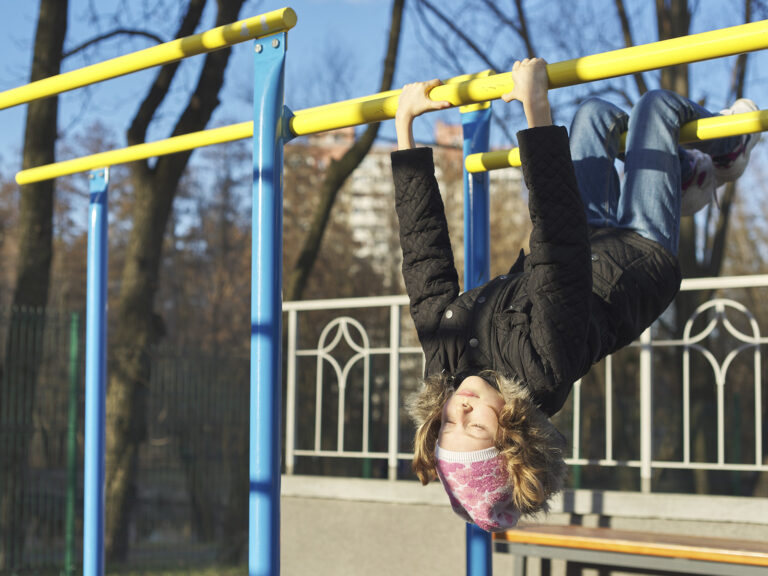 Niño ejercitando en barras parque actividad física
