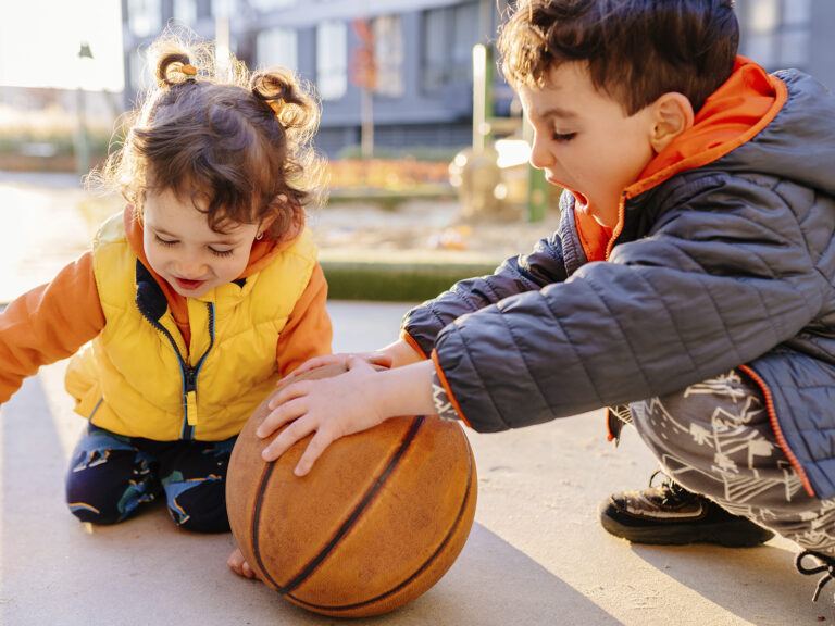 Niños jugando baloncesto en parque