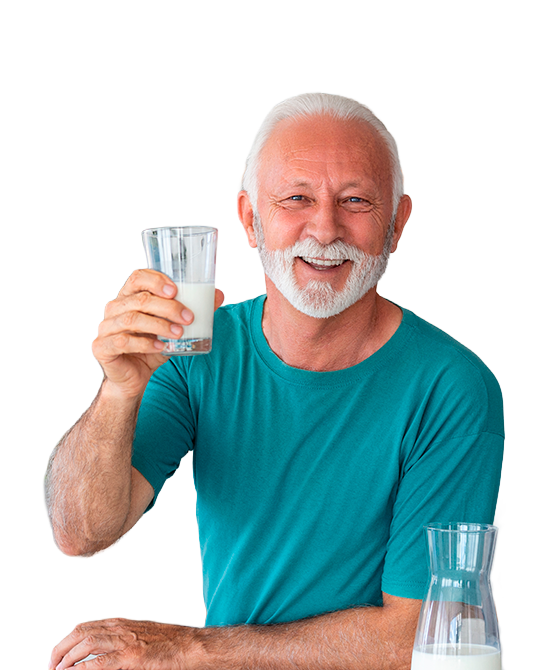 Hombre adulto mayor sonriente sosteniendo vaso de leche blanca