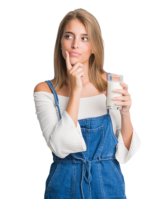 Mujer joven pensativa sostenie ndo vaso de leche Puleva Original