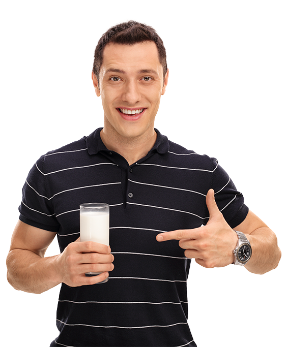 Hombre joven sonriente con vaso de leche haciendo gesto de aprobación con dedo pulgar