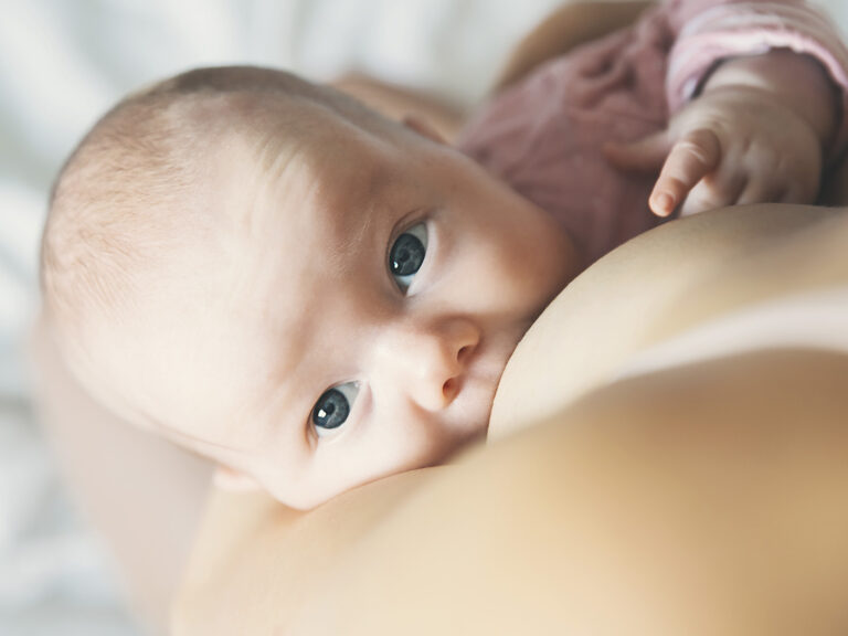Bebé recién nacido amamantándose del pecho de su madre - Lactancia materna