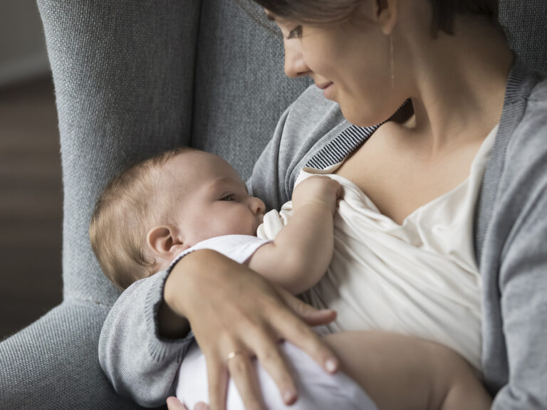 Madre amamantando a su bebé con cariño en brazos - Vínculo afectivo durante la lactancia materna