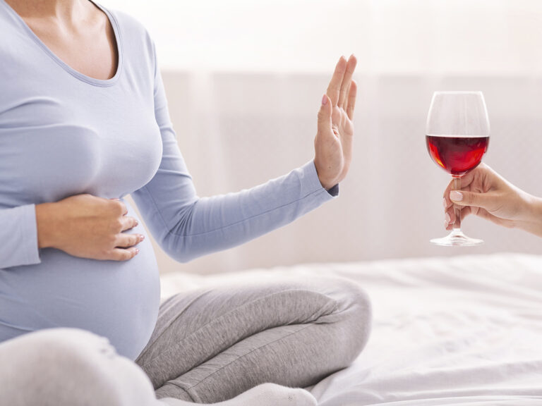 Mujer embarazada rechazando copa de vino