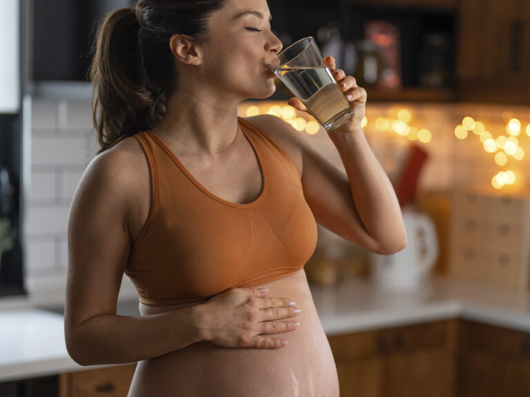 Mujer embarazada bebiendo agua para hidratación