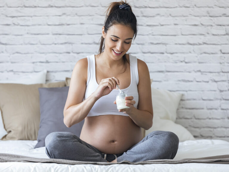 Mujer embarazada con vitaminas y medicinas