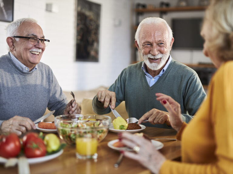 Personas mayores compartiendo comida y conversación