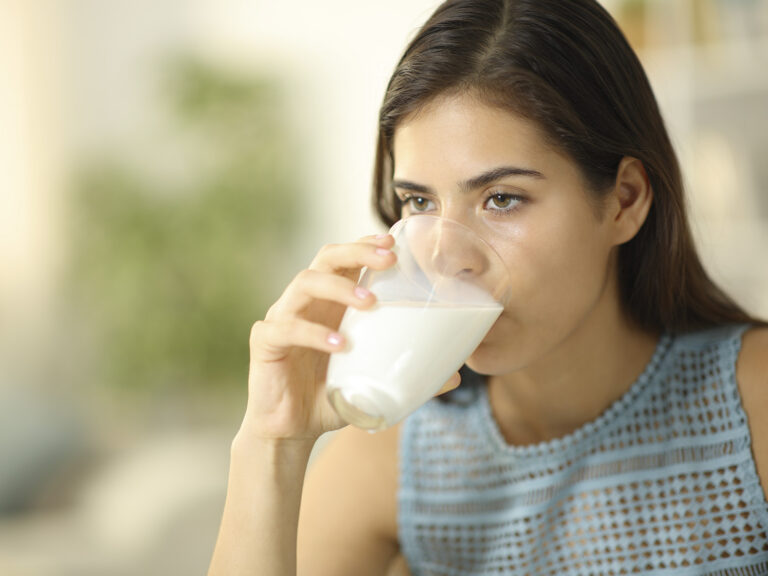 Mujer joven bebiendo vaso de leche