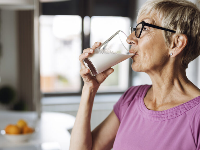 Mujer mayor bebiendo vaso de leche