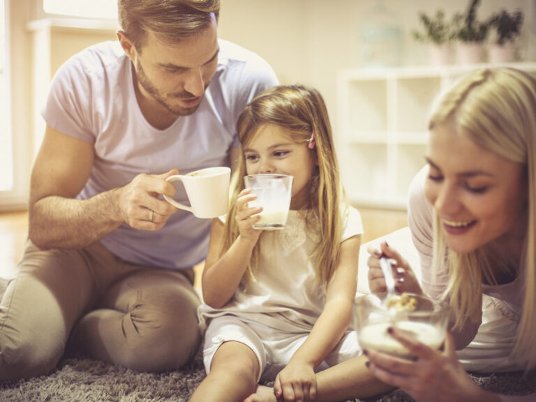 Familia padre e hija bebiendo leche juntos