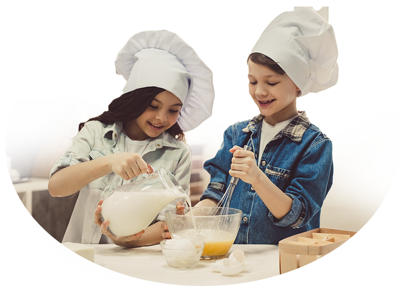 Dos niños cocinando juntos con gorros de chef - actividad familiar y educativa