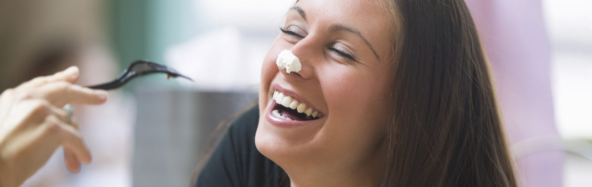Mujer disfrutando comiendo con tenedor sonriendo feliz