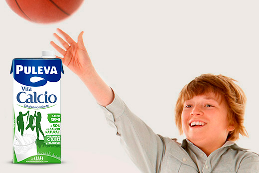 Niño feliz saltando botella Puleva Calcio - crecimiento fortaleza ósea infantil